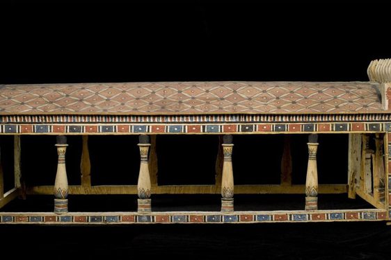 A wooden canoppy painted in a faded black, blue, and red pattern.