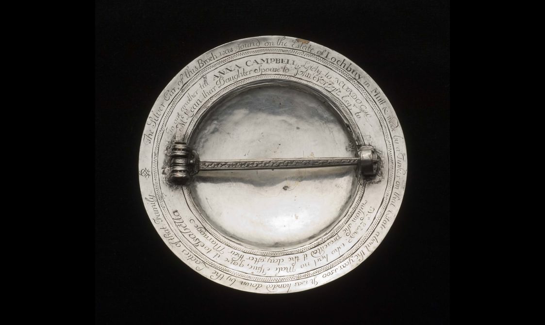 The rear of a silver coloured metal brooch with a horizontal clasp.