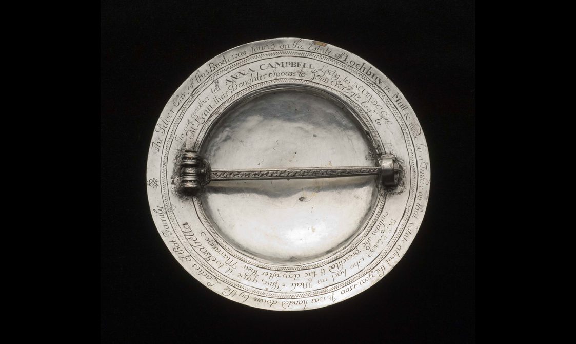 The rear of a silver coloured metal brooch with a horizontal clasp.