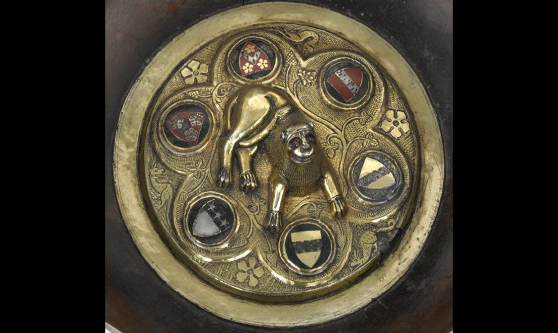 Gold insert of a wooden maple bowl. Insert is decorated with the image of a lion surrounded by 6 heraldic shields.