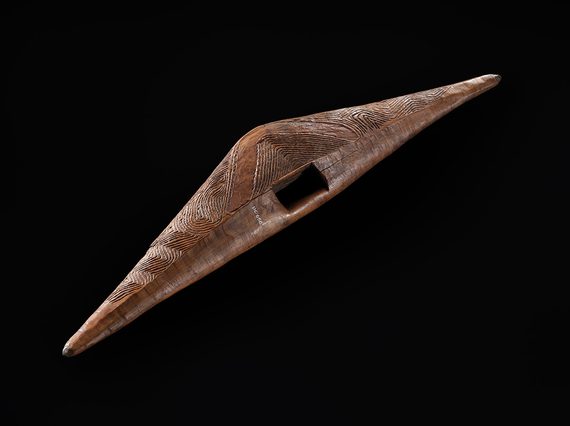 Wooden parrying shield with pointed ends and linear ornamentation on the two front faces with traces of white ochre