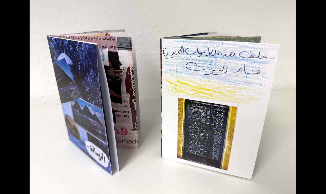 Two zines standing upright on a table. The zines have pictures of Egypt on them.
