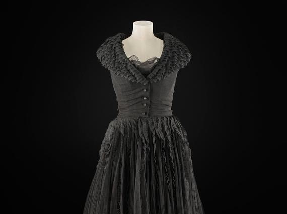 A knee length black dress on a torso mannequin