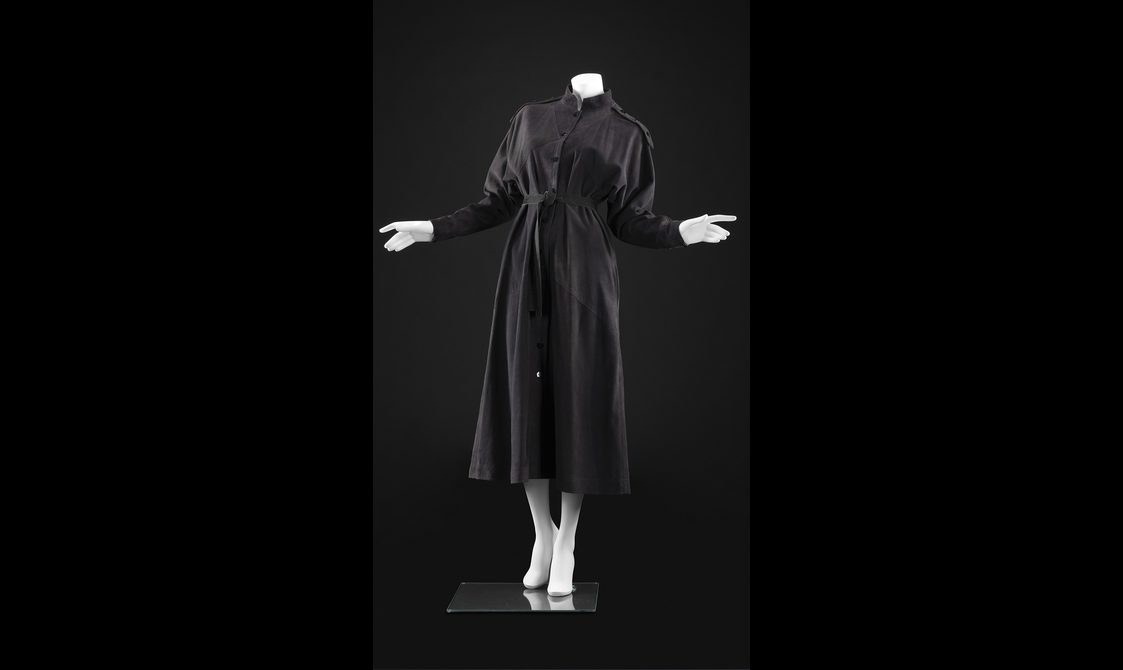 A manequin wearing a black shirt dress with long sleeves