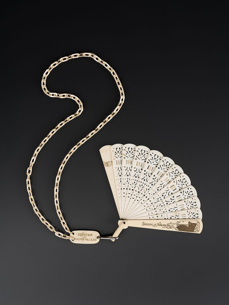 Brisé fan of imitation ivory in celluloid plastic with cream silk ribbon. Guards painted in gold colour with 'Souvenir of Niagara Falls'