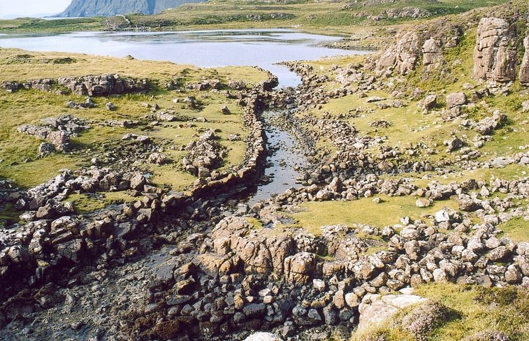 A rocky landscape on Skye showing a small manmade canal flowing into the sea