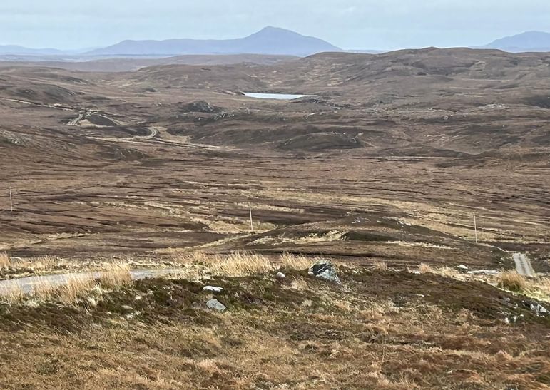 Landscape near Kirtomy, Sutherland featuring mountains, a trackway and peat banks.