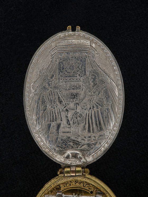 Close up of 17th century silver watchcase with royal portrait of James VI and Anna in court dress. Museum reference H.NL 63.