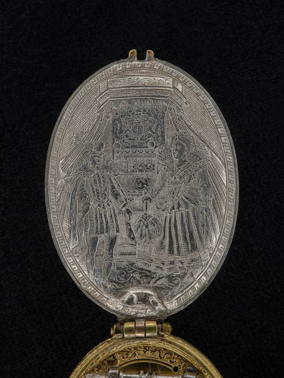 Close up of 17th century silver watchcase with royal portrait of James VI and Anna in court dress. Museum reference H.NL 63.