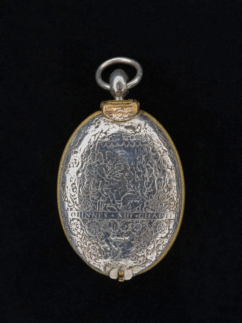 Silver watch outward facing with royal engravings.