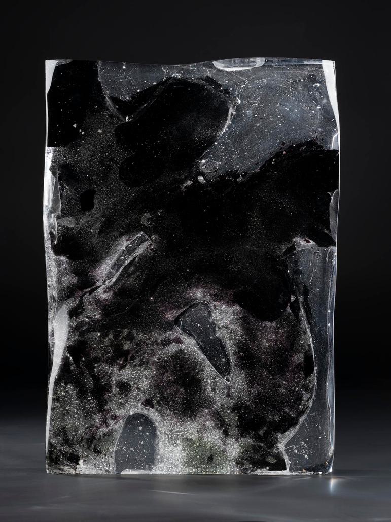 A rectangular block of glass with blotchy patterns on its surface.