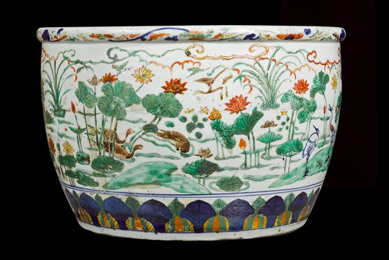 A large ceramic bowl with colourful decorative scenes of flowers and landscapes.