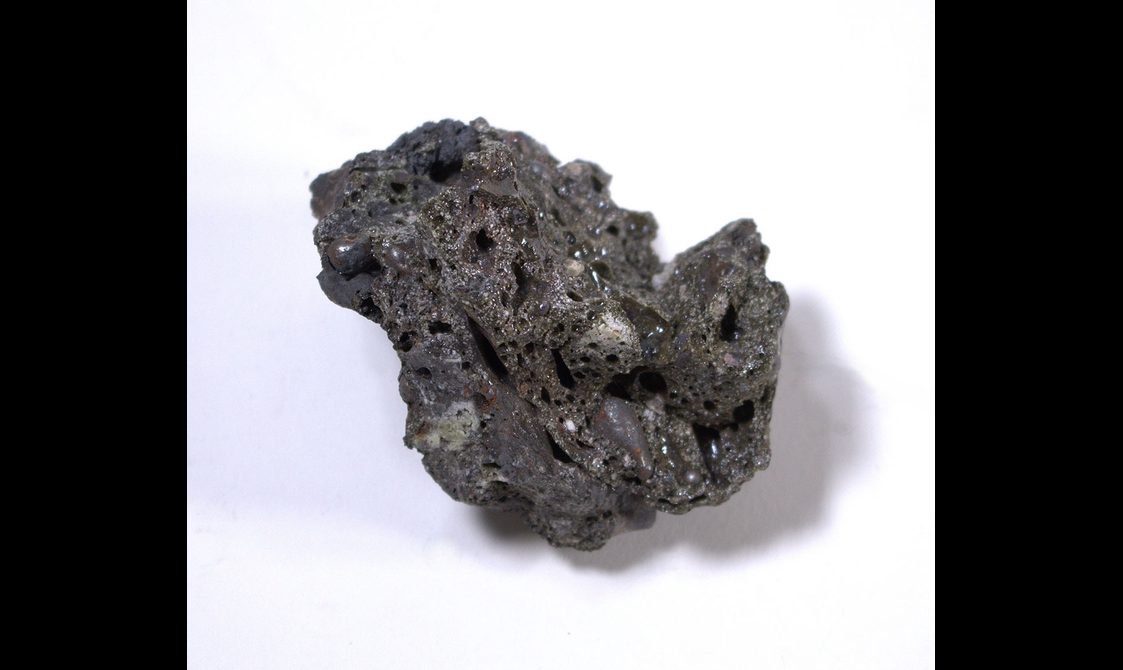 A piece of slag - a black the glassy, stony waste byproduct