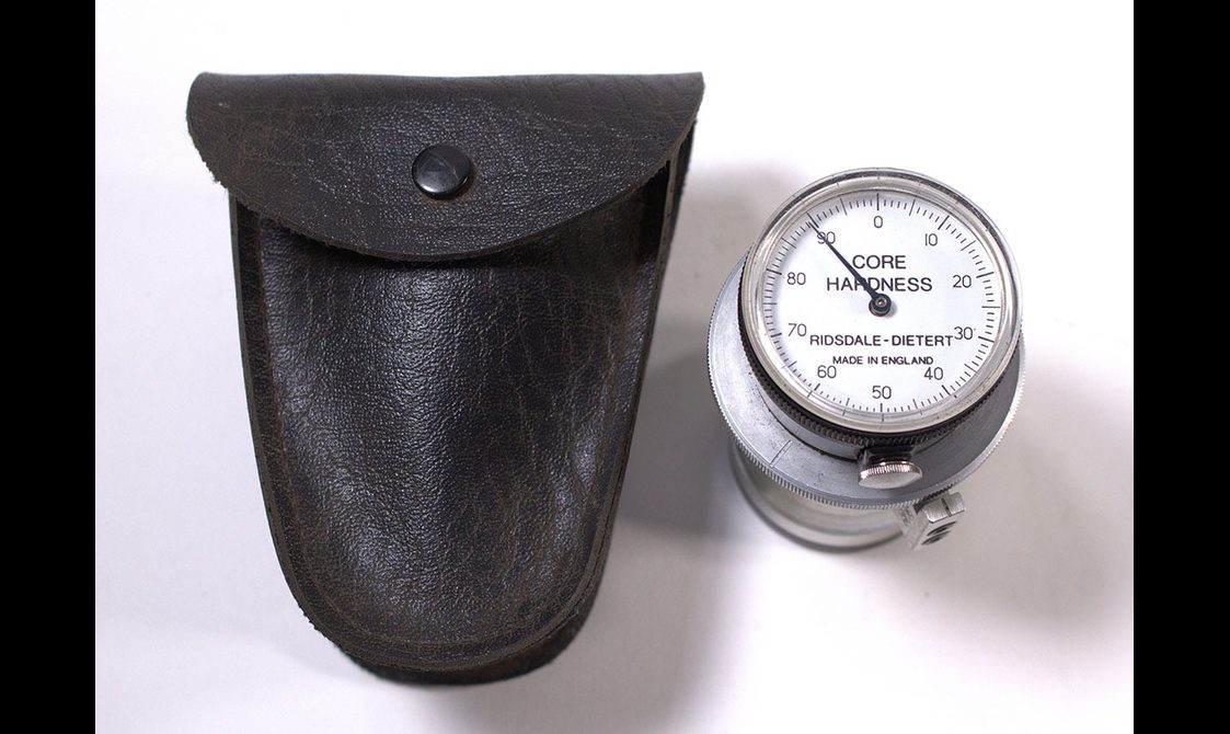 A black pouch with a small mechanical gauge