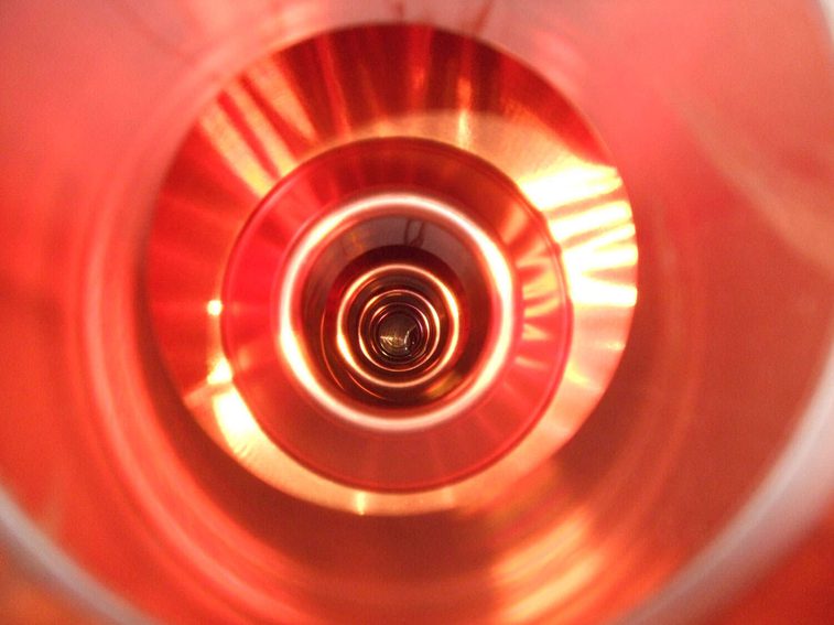 A colour photograph of the inside of a copper tub, showing concentric circular patterns.