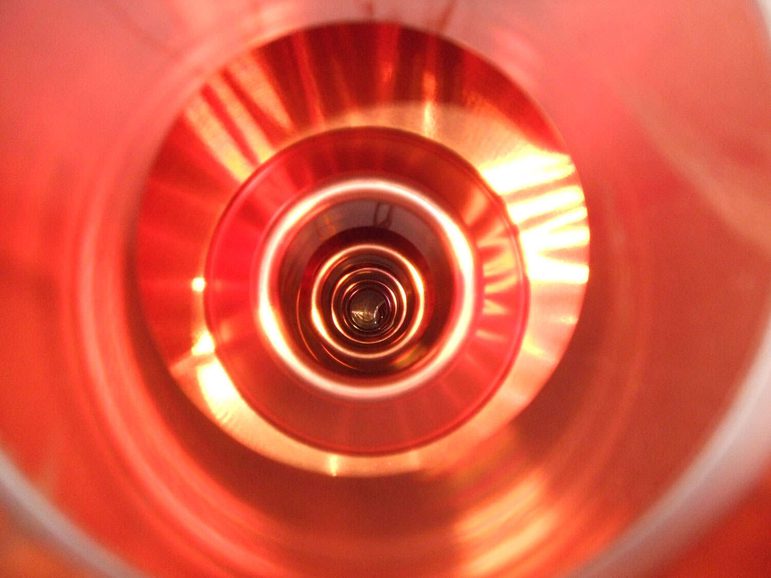 A colour photograph of the inside of a copper tub, showing concentric circular patterns.