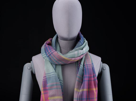 A mannequin wearing a purple, pink, and green scarf