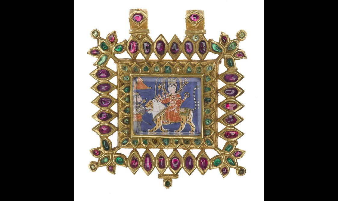 A highly decorated square gold brooch with pink and green oval gems around the edge and an image in the middle of a woman riding a tiger with an animal in front holding a flag and playing music.