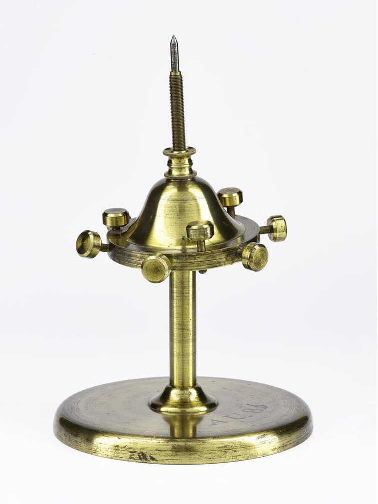 A brass dynamic top against a white background