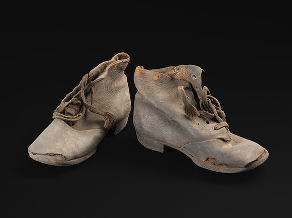 A small pair of leather, lace up ankle boots.