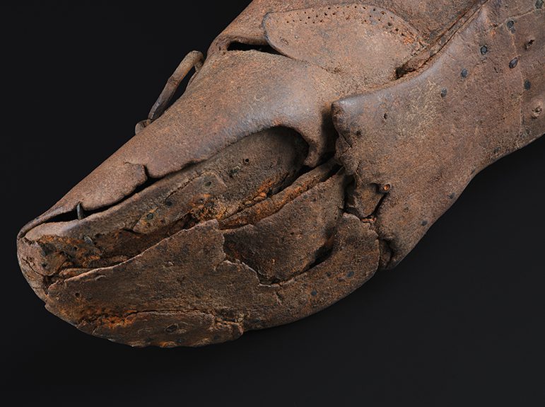 Close up of a small brown leather shoe.
