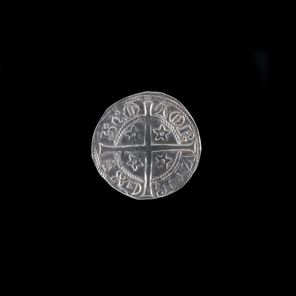 lat, silver penny with the image of a cross and four stars surrounded by Latin letters.