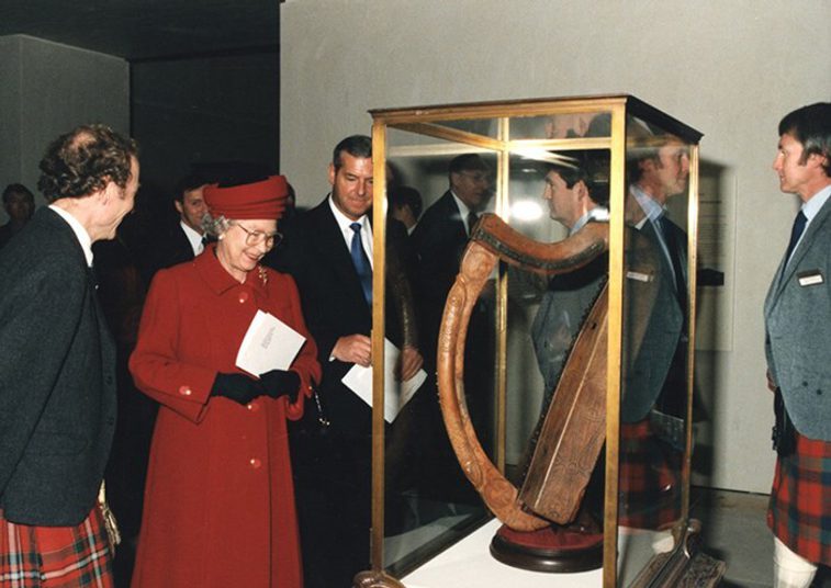 A colour photograph of Queen Elizabeth II looking at a museum exhibit