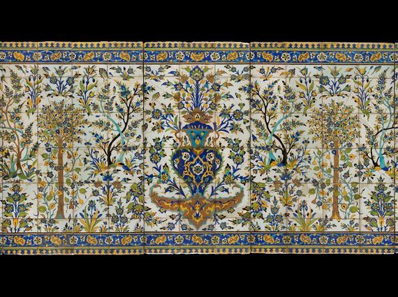 A long, rectangular panel made of hundreds of intricately decorated, painted tiles. This image gives the overall impression of the illustration, which from a distance is of a garden scene with trees all around, and a fountain as the centrepiece. The colours painted are yellow, blue, green and brown.