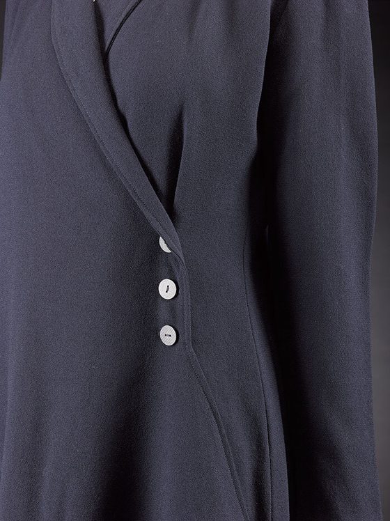 Detail of a navy wool crepe coat with three buttons fastening the coat.