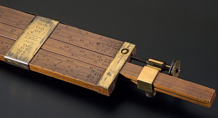 A colour photograph of a wooden instrument with brass fittings against a black background.