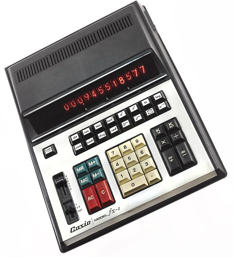A colour photograph of a very large 1970s calculator again a black background. The calculator has a red number display, a set of different keypads in cream, red, green and black combinations, and the word Casio Model FX-1 written at the bottom left.