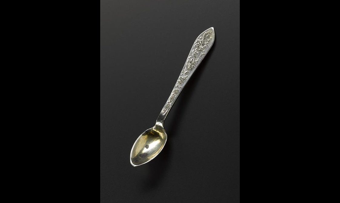 Silver spoon with floral decoration on the handle.