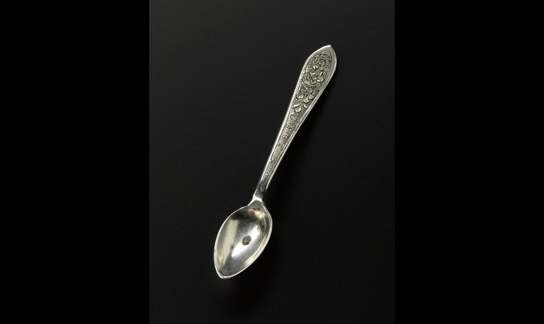 Silver spoon with floral decoration on the handle.