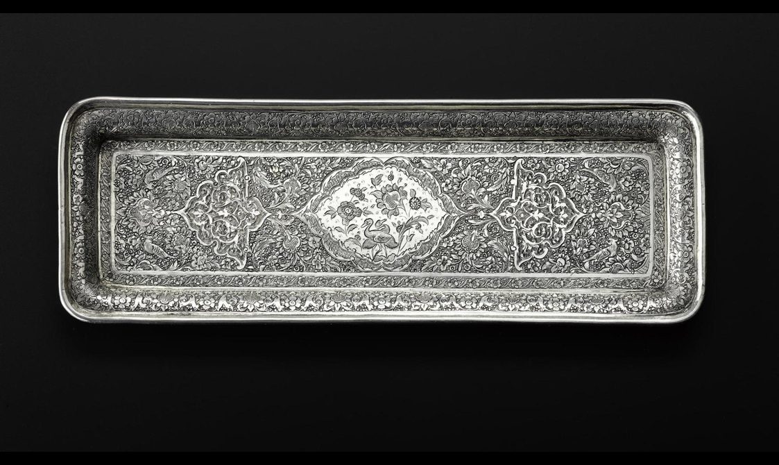 A long rectangular silver tray with detailed floral patterns engraved on its surface.