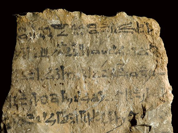 A yellowed stone with an inscription written in black ink.