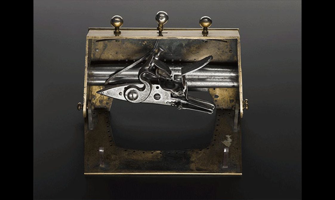 Front view of an open brass sporran clasp with hidden pistols inside.