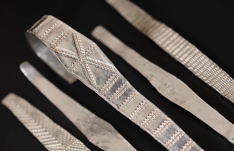 5 silver arm rings from the galloway hoard laid down side by side.