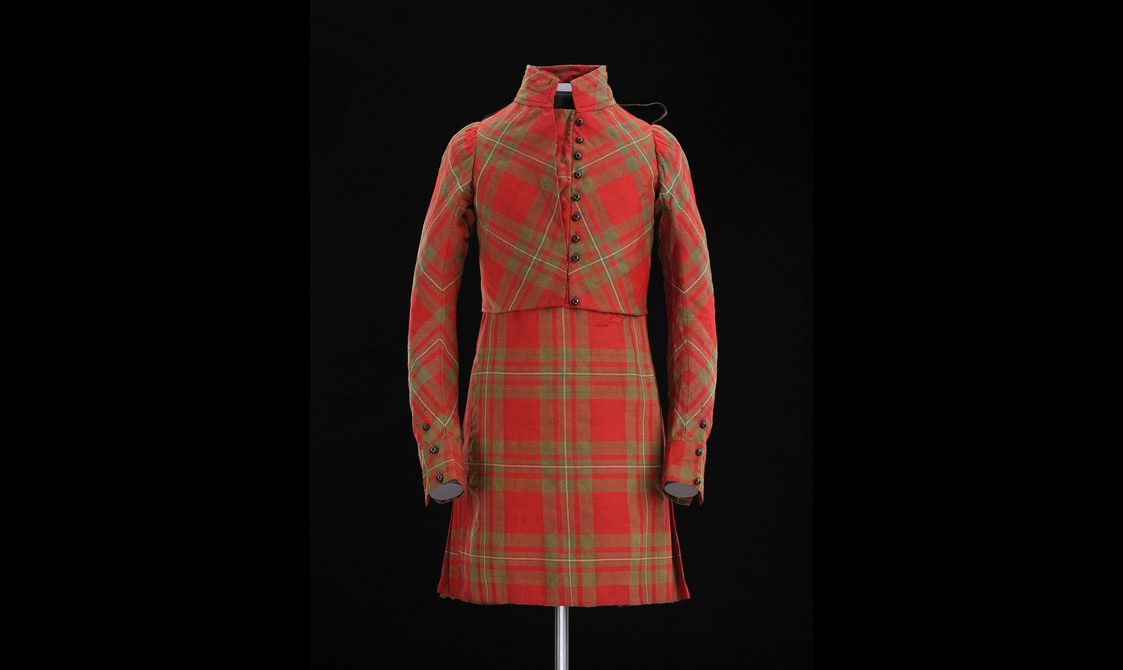 Mannequin wearing a red tartan kilt with a matching short jacket.