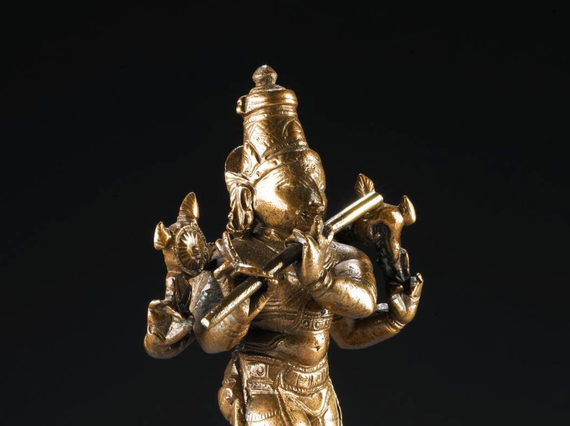 Bronze figure of Krishna, standing playing the flute.