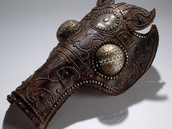 Reddish-brown leather helmet shaped like a horse's head. Its eyes are guarded with metal spheres resembling a fly's eyes.