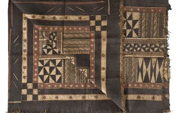 A piece of black and light brown textile laid flat with geometric designs.