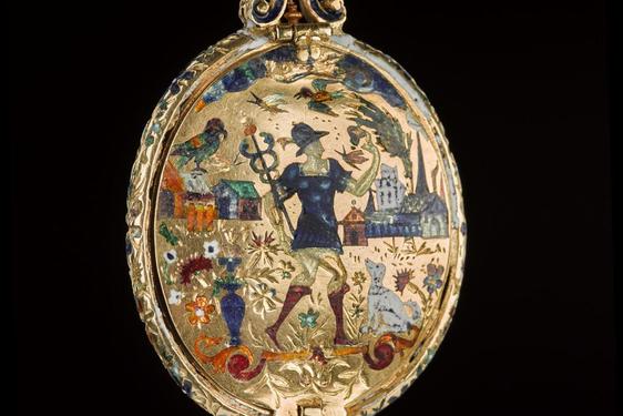 Golden, egg-shaped jewel against a black background. Decorated with a person in blue with a staff in an abstract, multi-coloured village.
