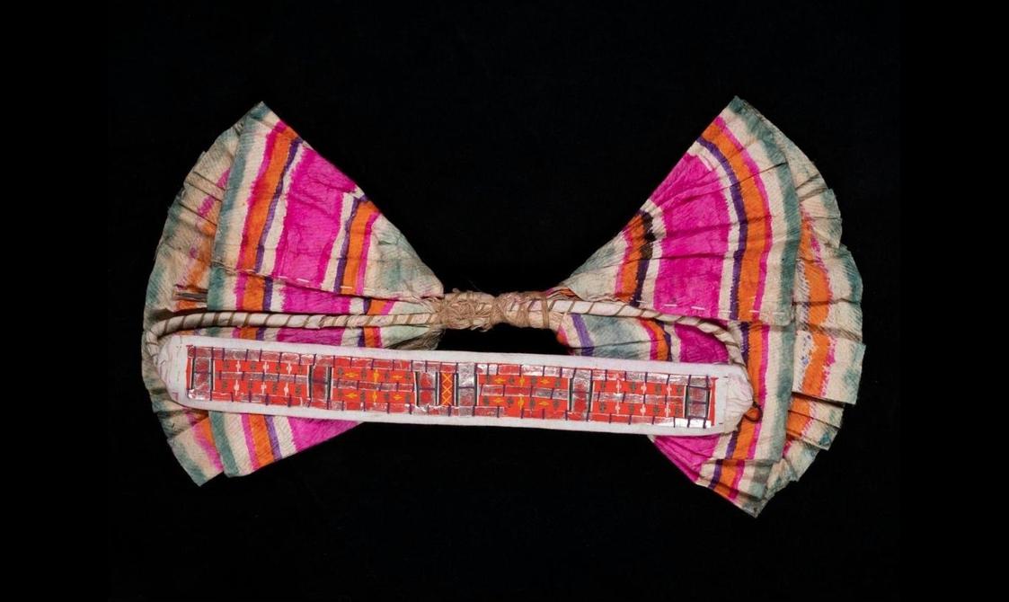 A bow made from pink, white, orange, and green striped fabric