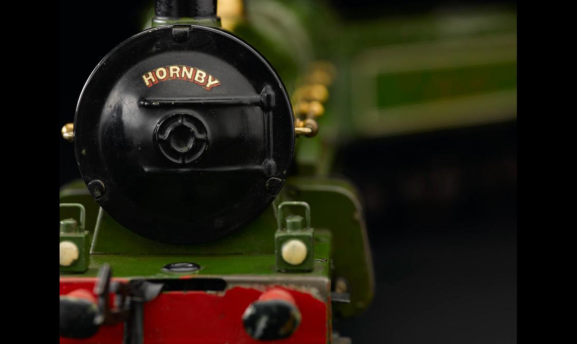 A detail of model train in red, green, and black.