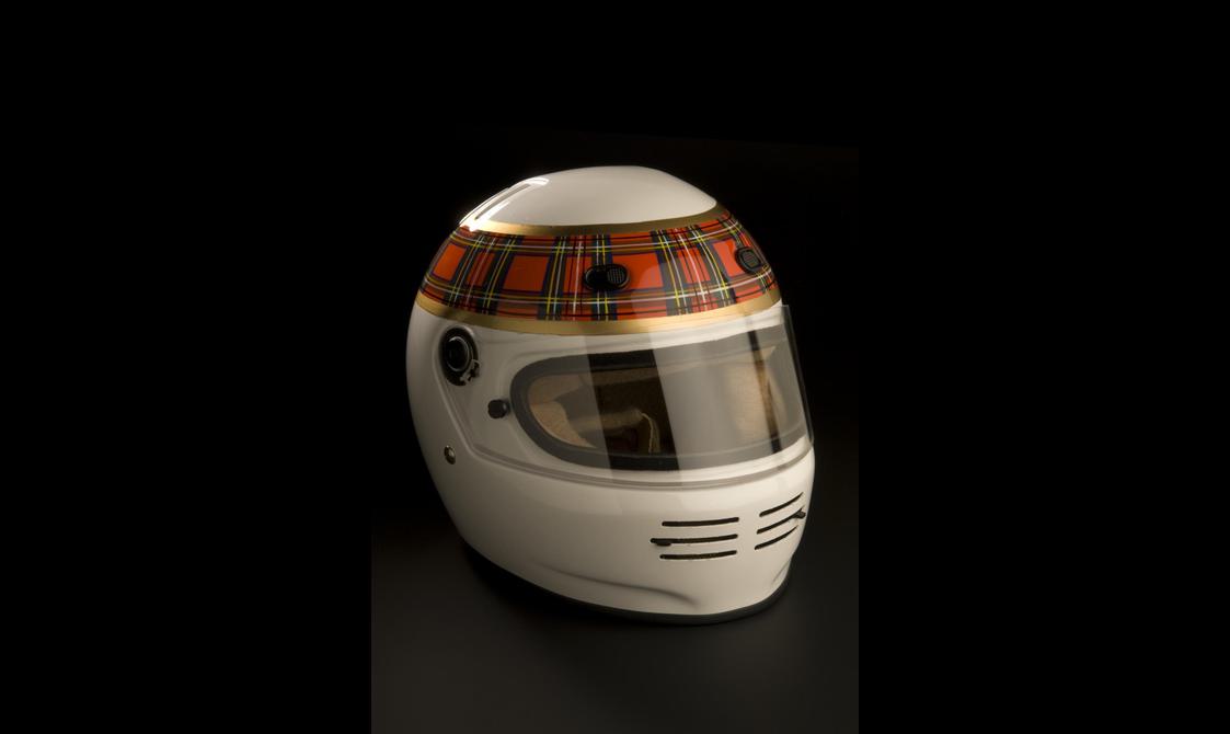 A white racing helmet with a red tartan band around the top