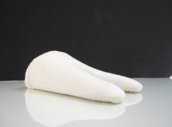 A white textile mount sitting on a white table with a black background.