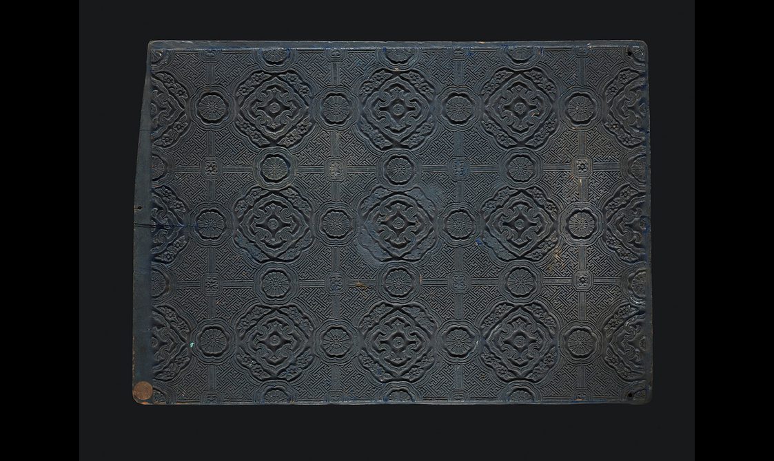 Wooden block with repeating design carved into it