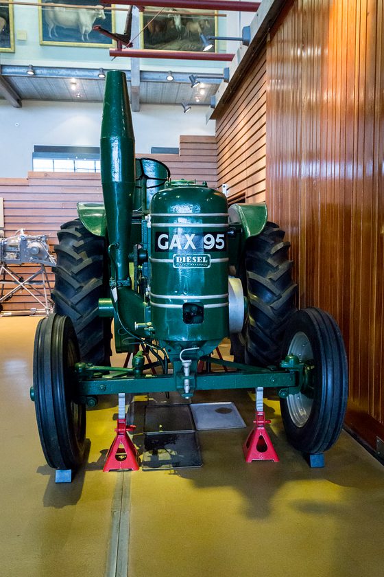 A colour photograph of a front view of a dark green tractor with a label that reads 'DIESEL' on the front and capital lettering that says 'GAX 95'. It has 2 large black rubber tyres at the back and 2 smaller rubber trees at the front.