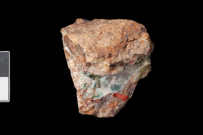 Pale pink small piece of rock with hints of pale blue and red.
