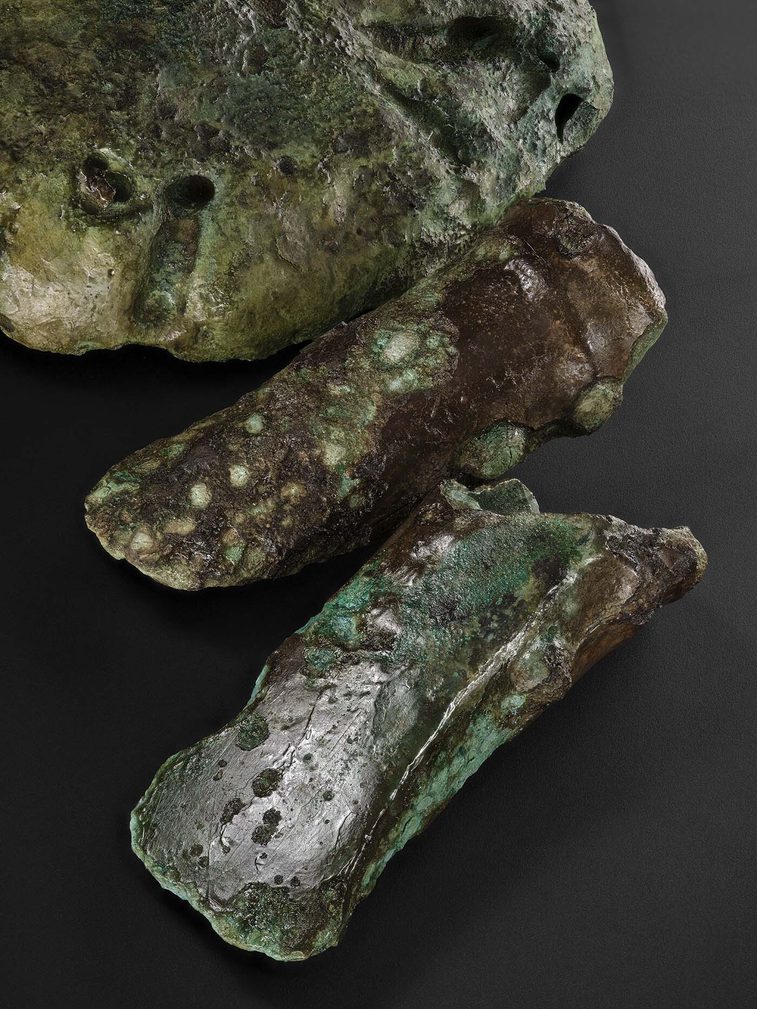 Three moulds from the Blyth Hoard on a dark background